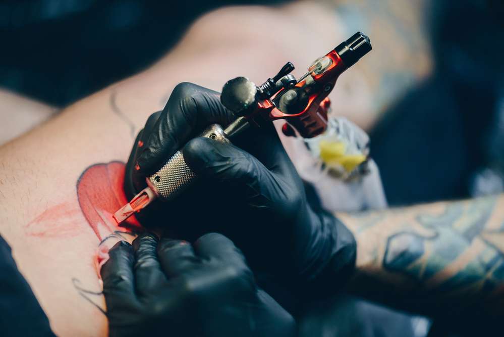 Premium Photo | Tattoo salon. the tattoo master is tattooing a man on his  shoulder. tattoo machine, safety and hygiene at work. close-up, tinted,  tattooist | Maquina de tatuagem, Tatuagem, Tatuador