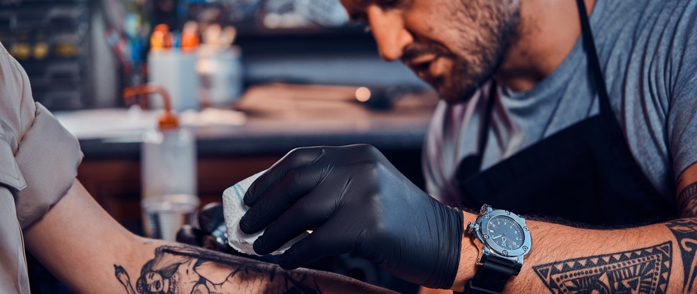 How long does getting a tattoo take? An artist tattoos a client's forearm.