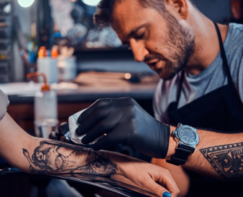 How long does getting a tattoo take? An artist tattoos a client's forearm.