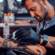How long does getting a tattoo take? An artist tattoos a client's forearm.