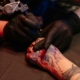 A tattoo artist uses a liner to begin the line work of a dragon tattoo. Such terms can be found in a tattoo dictionary.