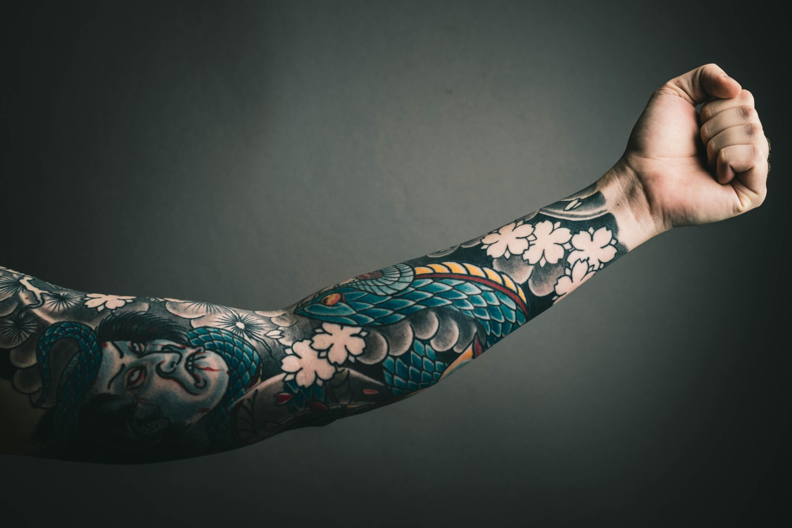 An arm sleeve featuring both color and black and white tattoo ink.