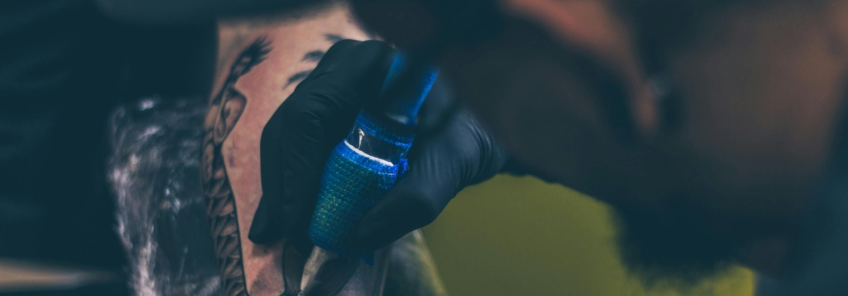 An artist placing an inner arm tattoo on a client.