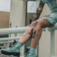 A woman in blue with many knee tattoos.