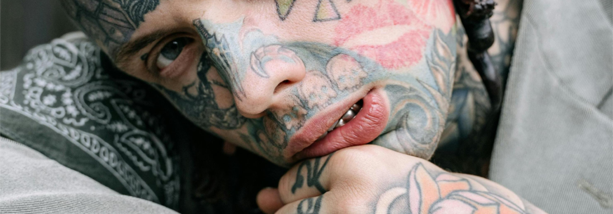 A tattooed gentleman ponders, "should I get an inner lip tattoo next?"