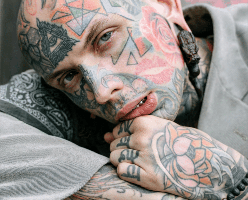 A tattooed gentleman ponders, "should I get an inner lip tattoo next?"